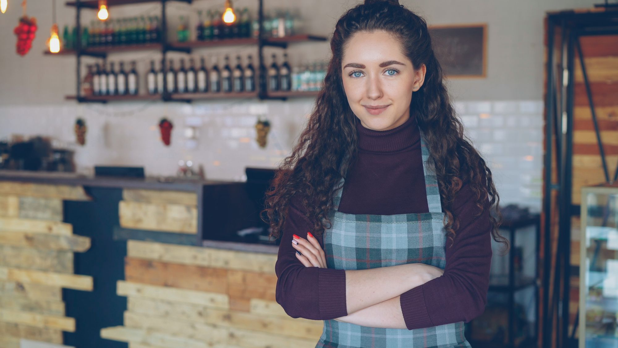 Small business owner standing confidently in her cafe