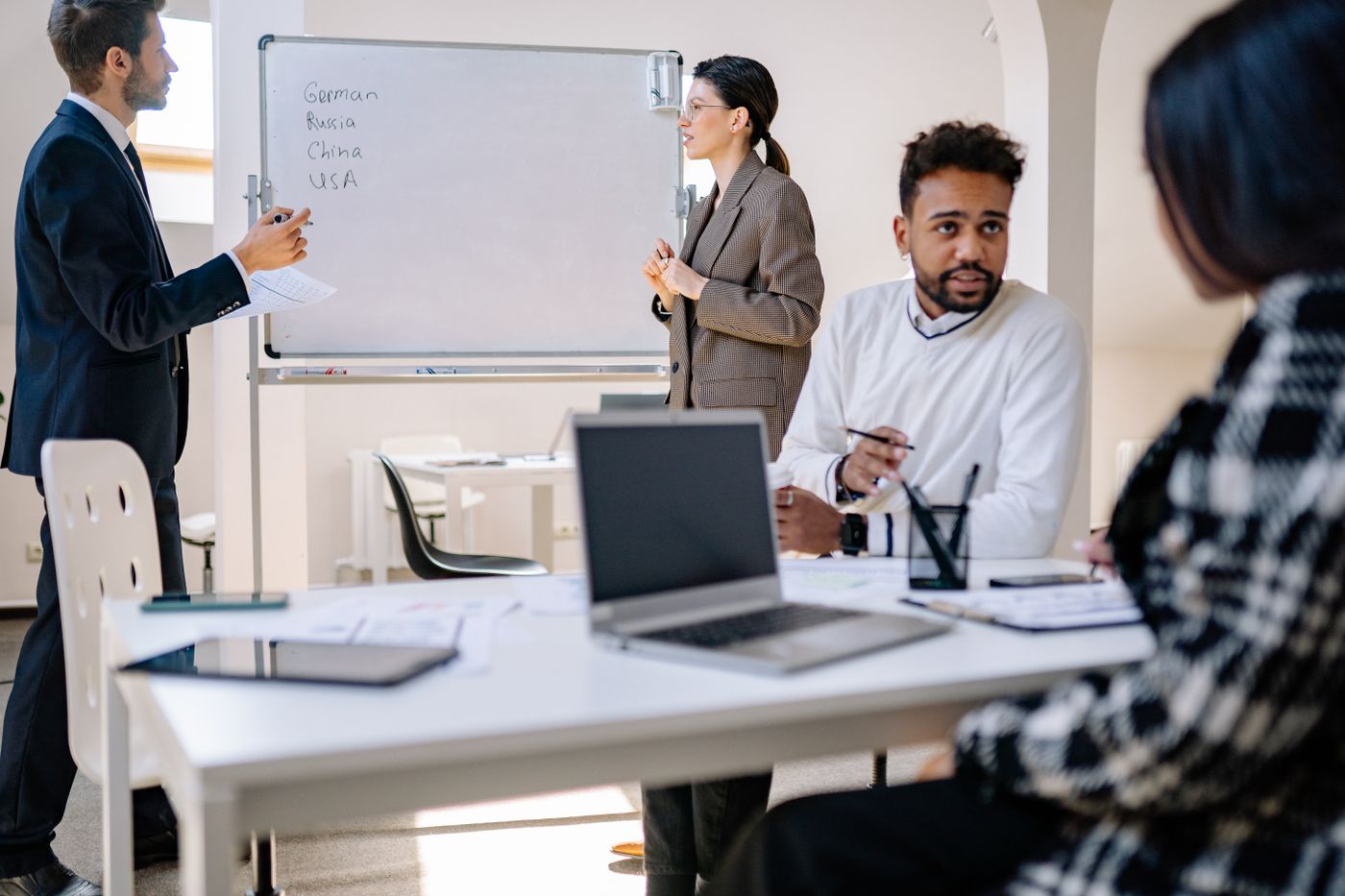 Group of business colleagues in discussion around a table in a bright office