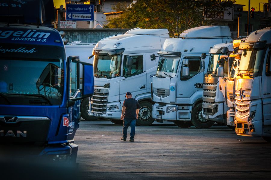 Line of freight trucks parked in an industrial lot at sunset